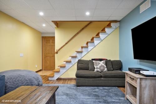 a living room with a couch and a staircase at Scout's Haven in Rolling Prairie