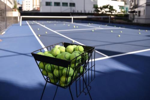 a basket of tennis balls on a tennis court at Plaza Inn Small Town Flat in Sao Paulo