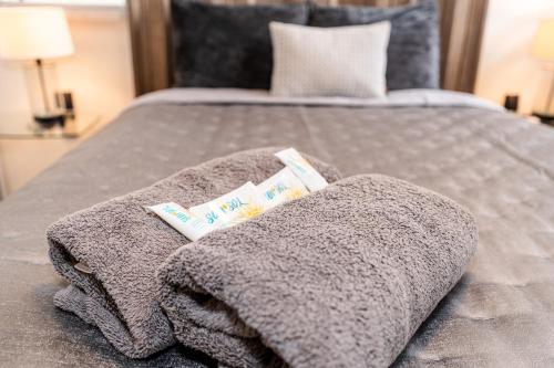 una manta gris en una cama con dos libros en Private Patio Retreat with Zen Vibe and FREE Laundry, en Ponce