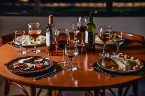 a table with two plates of food and wine glasses at Plaza Inn Small Town Flat in Sao Paulo