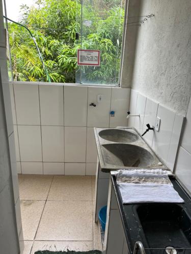 a kitchen with a sink and a window at Hotel da Gaúcha in Aragarças