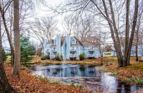 a large blue house with a river in front of it at Villa Signor in Norwich