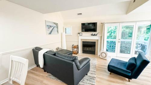 a living room with a black couch and a fireplace at Villa Signor in Norwich