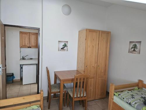 a room with a table and a bed and a kitchen at Penzion & ubytování in Chrást