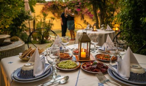 a table with plates of food and wine glasses at Ryad Mabrouka in Fès