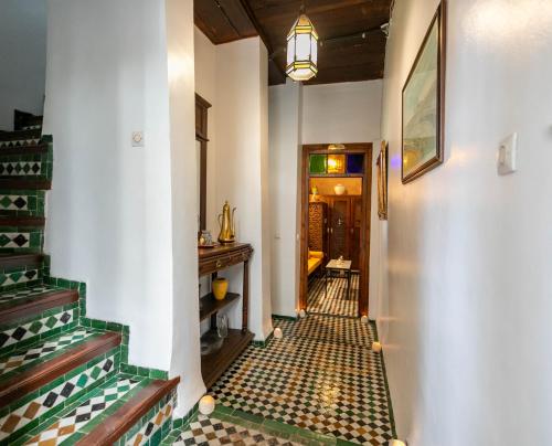 a hallway with tiled floors and a staircase in a house at Ryad Mabrouka in Fès