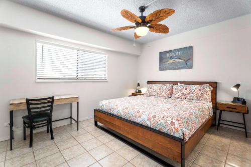 a bedroom with a bed and a desk and a ceiling fan at Kona Plaza#203 in Kailua-Kona