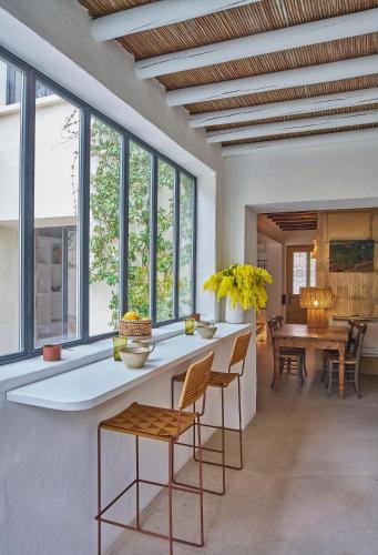 un salon avec une table, des chaises et des fenêtres dans l'établissement L'Arlésienne, à Arles