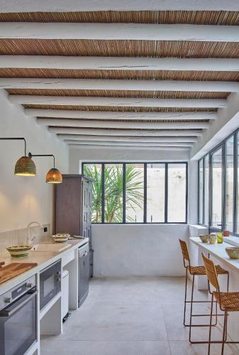 Il comprend une cuisine avec des plafonds en bois, une table et des chaises. dans l'établissement L'Arlésienne, à Arles