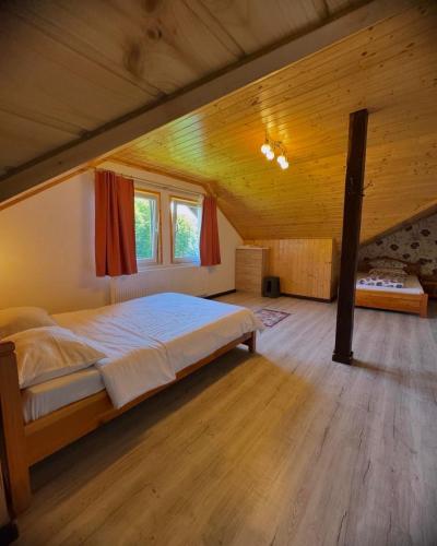 a bedroom with a large bed in a wooden room at Pensiunea 7 Brazi II in Poiana Mărului