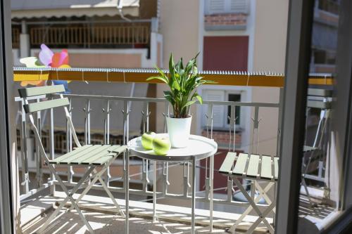 a table and chairs with a potted plant on a balcony at KK Athens Fine Stay-Steps to Metro-Modern & Cozy Apartments in Athens