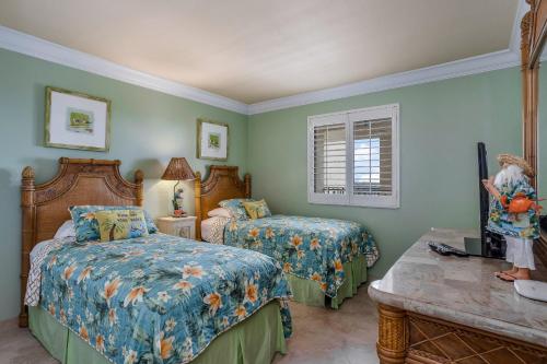 a bedroom with two beds and a table at Sanibel Sunsets in Fort Myers