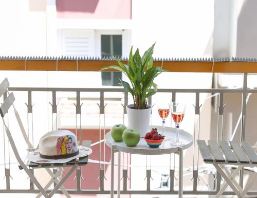a table with fruit and wine glasses on a balcony at KK Athens Fine Stay-Steps to Metro-Modern & Cozy Apartments in Athens