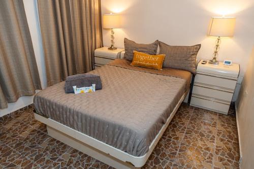 um quarto com uma cama grande e 2 mesas de cabeceira em Compact Haven with Private Entrance and FREE Parking and Laundry em Ponce