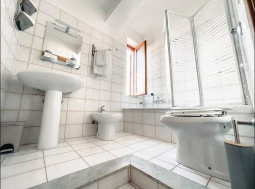 a white bathroom with a sink and a toilet at Three-Square house {apartment} in Gioiosa Marea
