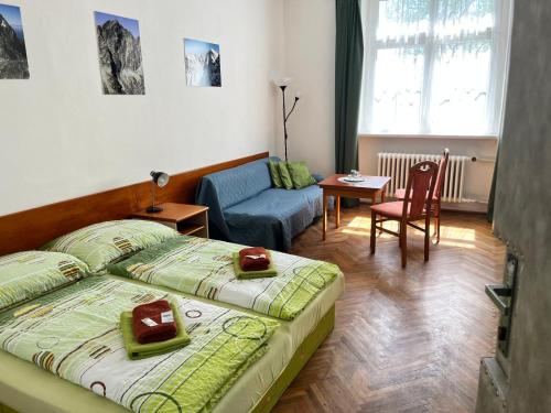 a bedroom with a bed and a chair and a table at Penzion Villa Gerlach in Vysoke Tatry - Novy Smokovec