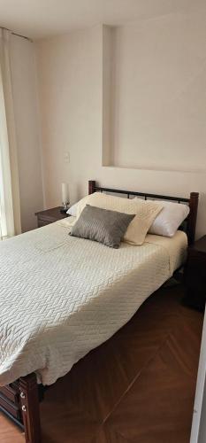 a bedroom with a large bed with white sheets and pillows at Villa Rosita in Tunja