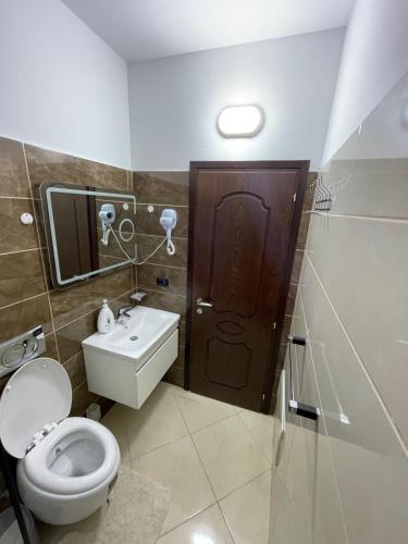 a bathroom with a toilet and a sink at Vila AT in Berat