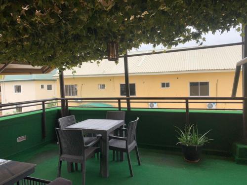 a table and chairs on the balcony of a building at Rivalex Apartment and Rooftop in Abuja
