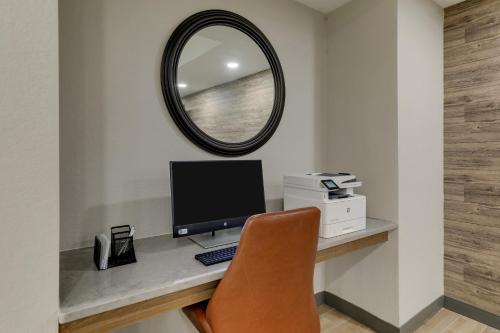 einen Schreibtisch mit einem Computer und einem Spiegel in der Unterkunft Candlewood Suites Lexington, an IHG Hotel in Lexington