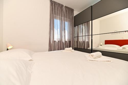 1 dormitorio con 1 cama blanca grande y toallas. en Apartment Marko en Trogir