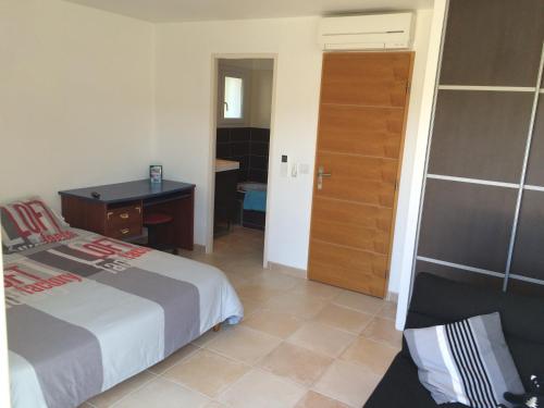 - une chambre avec un lit, un bureau et une porte dans l'établissement villa aureliana, à Saint-Raphaël