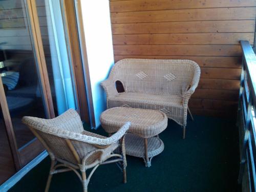 a porch with two chairs and a chair and a table at Appartement À La Jorette-Torgon in Torgon