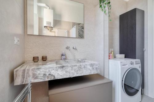 a bathroom with a sink and a washing machine at Lattanzio Charming Suite - Porta Romana MM3 in Milan