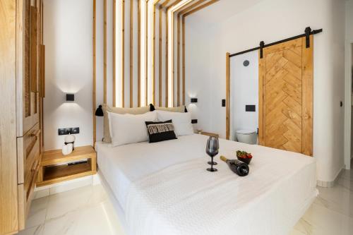 a bedroom with a large white bed with a wooden door at Lago m Superior Naxos Town in Naxos Chora