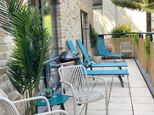 a patio with blue tables and chairs and a grill at Friends & Family Brussels Atomium 6-8 pers in Grimbergen
