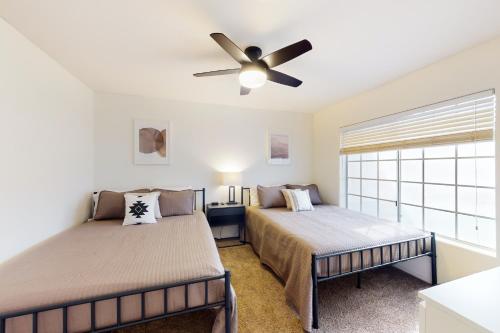 a bedroom with two beds and a ceiling fan at Peoria Palms in Peoria