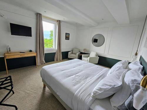 um quarto com uma grande cama branca e uma janela em La Suite Gignac em Gignac