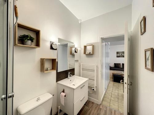 une salle de bain blanche avec des toilettes et un lavabo dans l'établissement Les bords du Clain - Entrée Autonome Studio, à Poitiers