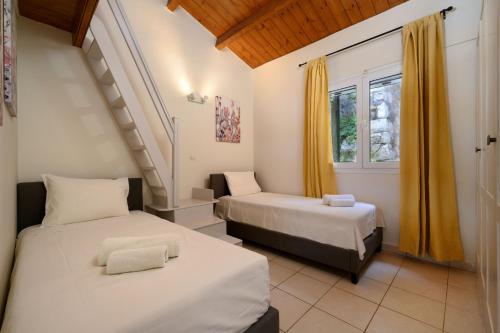 a bedroom with two beds and a window at Corfu Glyfada Beach Apartment in Glyfada