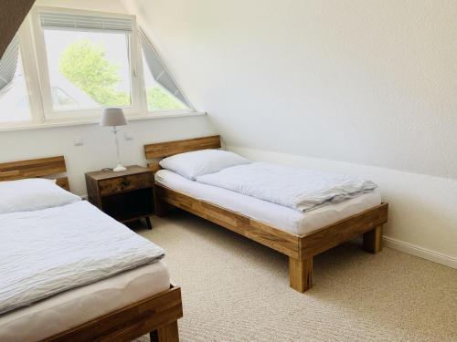 a bedroom with two twin beds and a window at Johannsen-Huis-Appartement-Dena in Tinnum