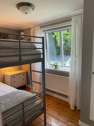 a bedroom with two bunk beds and a window at Stuga Tjörn/Almösund in Almösund