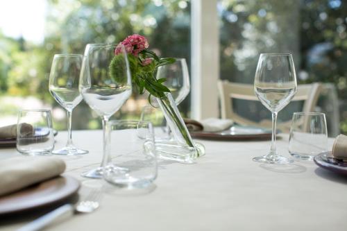 a table with wine glasses and a flower in a vase at Villa Abbondanzi Resort in Faenza