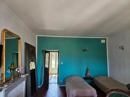 Cette chambre comprend 2 lits et un mur bleu. dans l'établissement Chambre parentale avec séjour, à Rapale