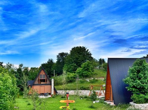 una piccola casa in un campo con un prato di Albero Casa a Cetinje (Cettigne)