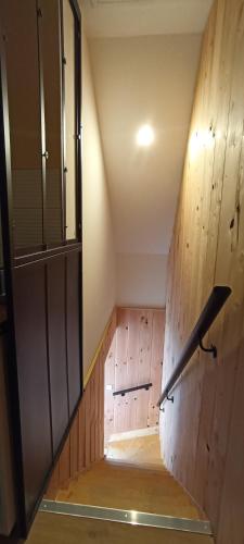 une pièce vide avec un mur en bois et un escalier dans l'établissement Le petit Herils, à Maisons
