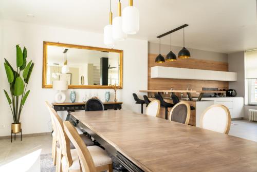 a dining room with a large wooden table and chairs at Villa" le Relais " sur la digue de Wimereux in Wimereux