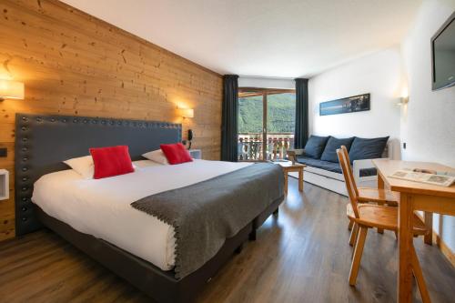 um quarto com uma cama, uma mesa e um sofá em L'Arcalod Hôtel Restaurant & Spa em Doussard