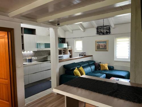a living room with a blue couch and a kitchen at Wolf country haus in Sesvete
