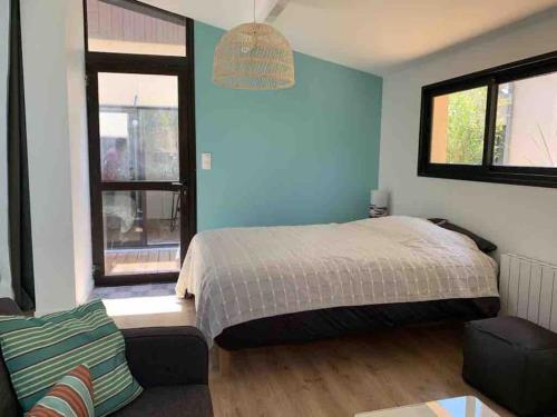 - une chambre avec un lit, un canapé et deux fenêtres dans l'établissement Lacanau Océan, grand logement, grandes terrasses, pinède, à Lacanau-Océan
