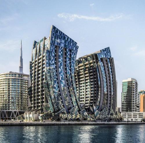 a group of tall buildings next to a body of water at GLOBALSTAY J One Tower Apartments at Pearl of UAE in Dubai
