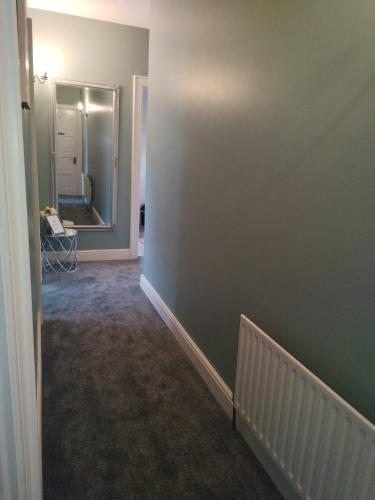 a room with a hallway with green walls and a mirror at Parkhill House Self Catering in Ballyshannon