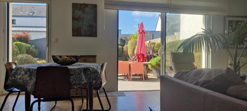 un salon avec une table et un canapé dans l'établissement Maison de vacances à 5 min des plages, à Ploemeur