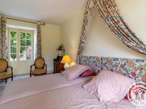 a bedroom with a large bed with a head board at Séjour de charme avec piscine à Saint-Georges-sur-Layon, proche de Saumur et des châteaux de la Loire - FR-1-622-81 in Méa