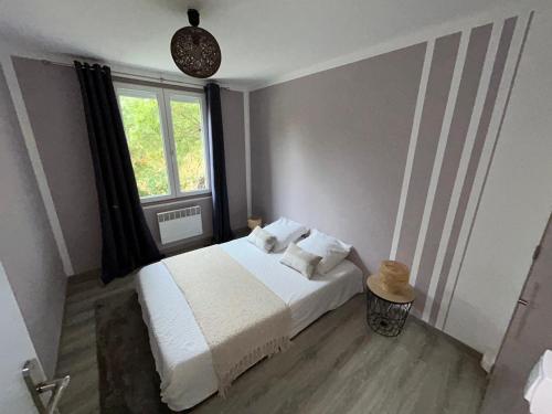a bedroom with a white bed and a window at Le Belvédère + Clim + Extérieur + Parking Gratuit in Les Angles Gard