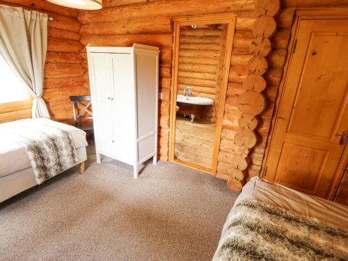 a bedroom with a sink in a log cabin at 10 Duck Lagoon in Tattershall